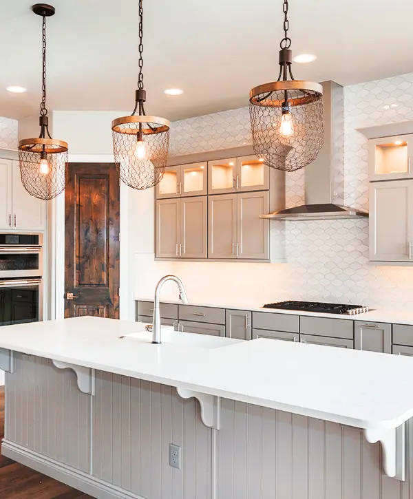 Modern kitchen with gray cabinets, large island, and pendant lighting