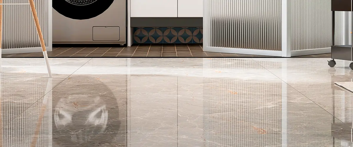 Modern laundry area with glossy gray floor tiles and geometric backsplash