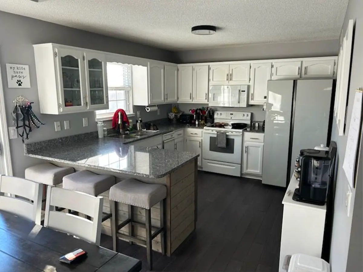 Outdated kitchen with white cabinets and granite countertops, ready for remodeling and updating.