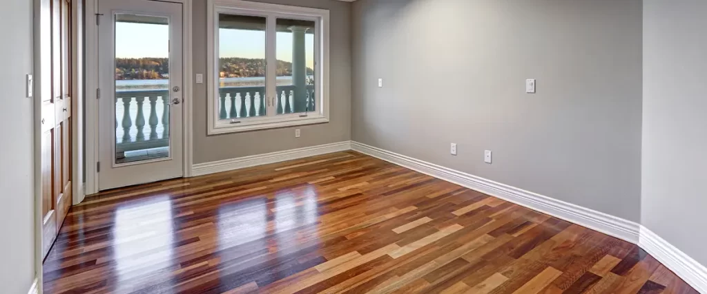 Empty room with hardwood flooring, crown molding, and a balcony view, ideal for home remodeling or interior renovation.